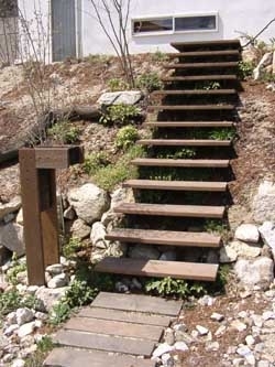 敷地を上手く利用した　玄関アプローチ 鉄と木の階段を自然な植栽を見ながら上がる