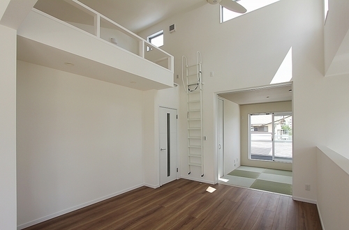 吹抜の高い天井のリビングルーム上にロフト。奥には琉球畳の和室も。